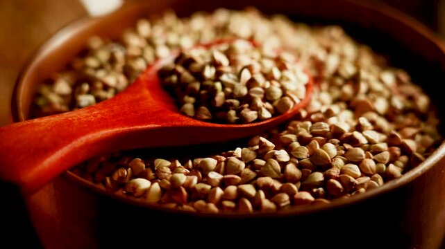 Organic Green Buckwheat grains in wooden bowl with red spoon for cooking