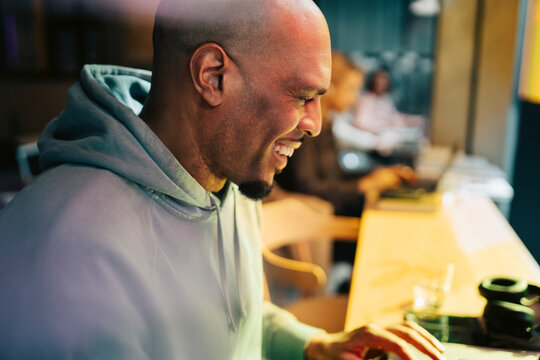 Happy businessman with shaved head working at modern coworking hub