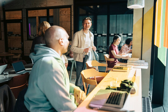 Diverse colleagues interacting and working in modern coworking hub