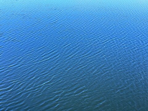 River water blue calm surface with ripples background.