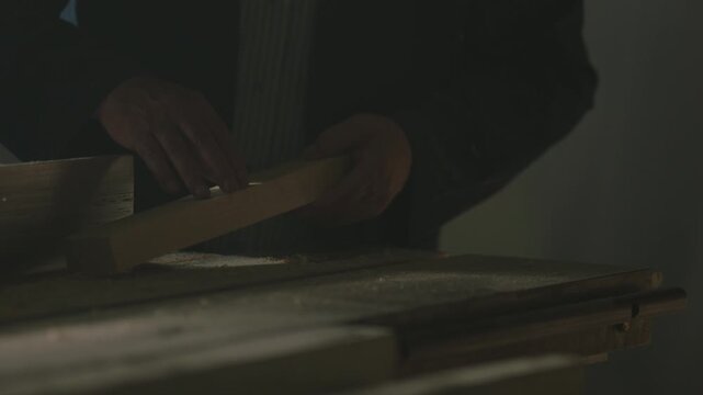 Detailed footage of a carpenter precisely aligning and working on a piece of wood.