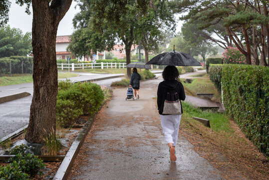 Woman with umbrella walking towards Saint-Jean-de-Luz, French Basque Country.