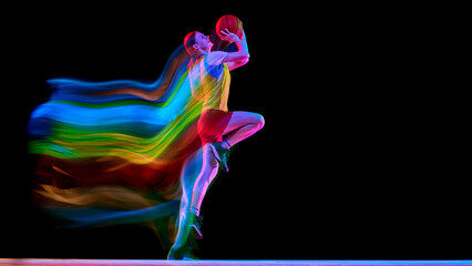 Obraz premium Female basketball player lifting ball for shot with colorful motion trail. Concept of shooting practice, performance mindset, sports poster covers, and women basketball promotion.