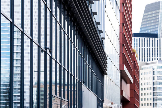 Glass facade lines frame a La Defense office canyon in Paris, France, where skyscraper reflection and financial architecture recede between towers