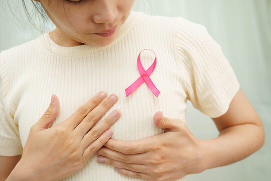 Asian woman with pink ribbon for October world breast cancer day.