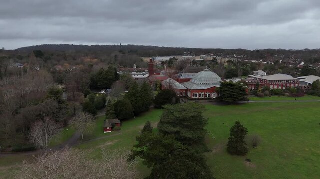 Wide drone pan across Avery Hill Pavilion and surrounding parkland under overcast skies.