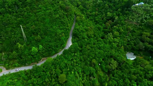 Aerial view of a RV parked on a mountain road in green forests of Liguria, Italy