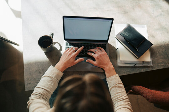 Directly above view of male freelancer preparing reports on laptop at shared coworking space