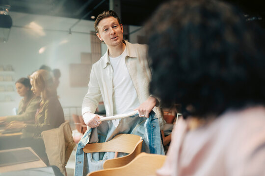 Young male entrepreneur talking with female colleague at modern coworking space