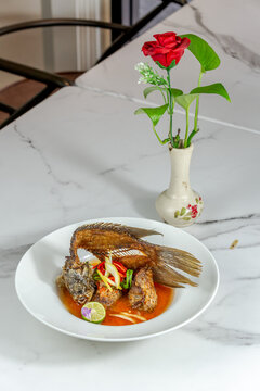 Indonesian pecak gourami fish with spicy sauce, close up traditional food photography for restaurant menu
