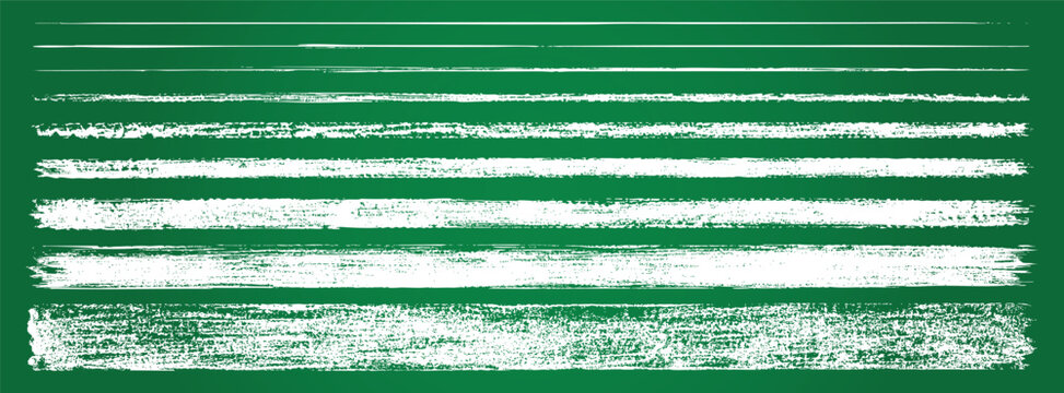 Collection of various hand-drawn white chalk lines, textures, and strokes isolated on a green blackboard background.
