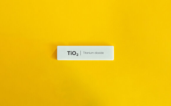 TiO2 Titanium Dioxide Chemical Formula Text on a White Block Against Bright Yellow Background