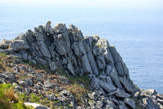 M&auml;chtige, zerkl&uuml;ftete Granitfelsen ragen steil am Kap empor und bilden eine raue Barriere zwischen der kargen K&uuml;stenheide und dem unendlichen Blau des Meeres.