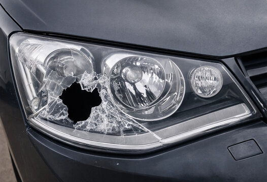 Close-up of a shattered and broken car headlight after front end collision or minor road accident
