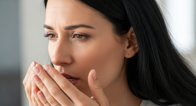 Concerned Young Woman Holding Hands to Mouth Feeling Unwell or Checking Breath