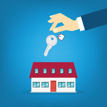 Hand holding key over the house. House buying