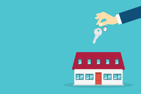 Hand holding key over the house. House buying
