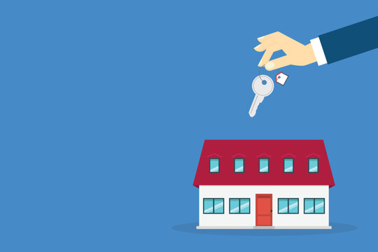 Hand holding key over the house. House buying