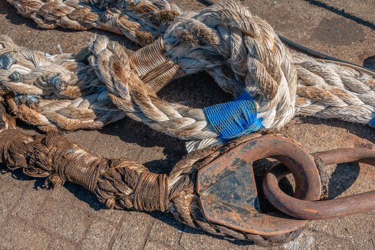 Closeup of heavy braided and reinforced ropes on the quay of a Dutch port.