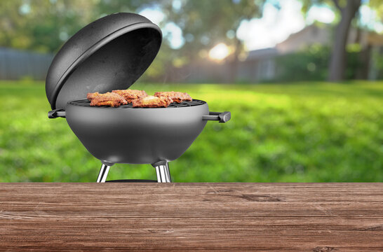 summer time in backyard garden with grill BBQ, wooden table, blurred background
