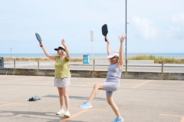 Obraz premium Senior women playing pickleball enjoying active lifestyle