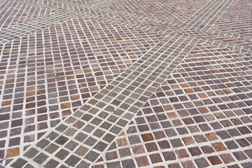 Fototapeta premium High angle view of a rustic cobblestone pavement texture with square stone blocks arranged in diagonal rows