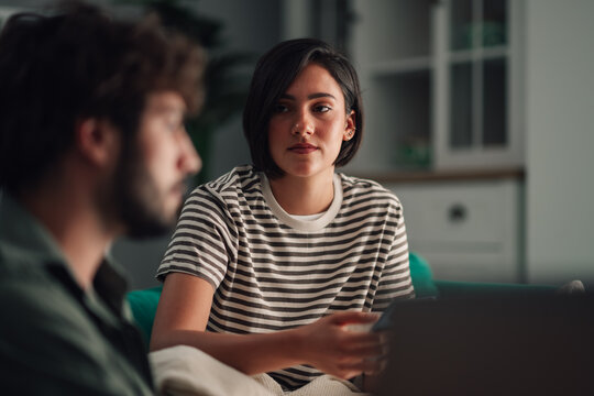 Young woman engaging in a serious conversation with her partner, actively listening and discussing important matters in a home setting