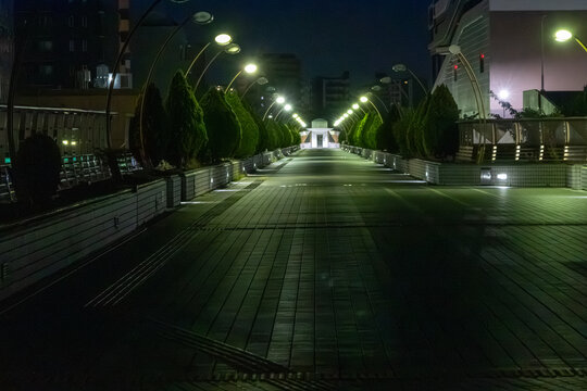 Illuminated pedestrian bridge at night with converging perspective