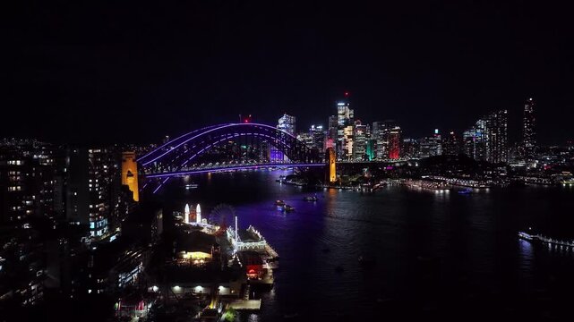 Up over Lavender bay on Sydney harbour at Vivid Sydney night light show aerial view.