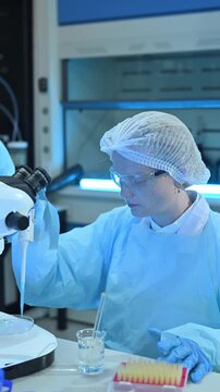 Female Scientists Working in Modern Research Laboratory with Microscope and Laptop