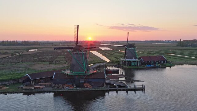 Aerial view of historical dutch windmills at zaanse schans in holland. Beautiful sunset over the serene landscape with canals and water