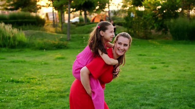 a mother and her child are walking and having fun in the park in the summer, a mother and a small child on a green lawn