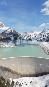 Kops Dam And Reservoir Near Silvretta Mountains In Austria. vertical, aerial pullback shot