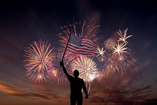 Man with National flag of United States of America in sky with fireworks