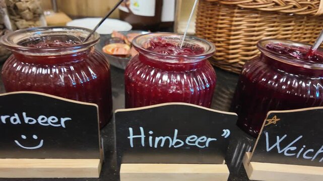 Strawberry and raspberry jam jars on hotel breakfast buffet