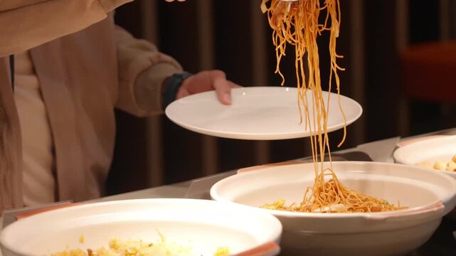 20250521_FX3c31009 Guest picking hot stir fried noodles with tongs at a luxury hotel buffet line station