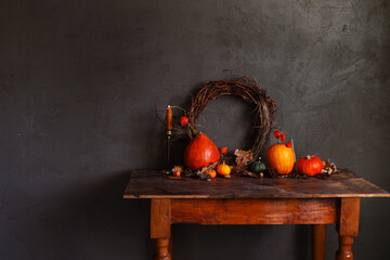 Autumn still life. Colorful pumpkins, autumn leaves, acorns, stylish wreath and candle on rustic...