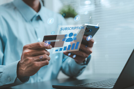 Global subscription services business model concept businessman holding credit card and smartphone with holographic user growth chart and multi currency symbols, recurring payment, membership growth