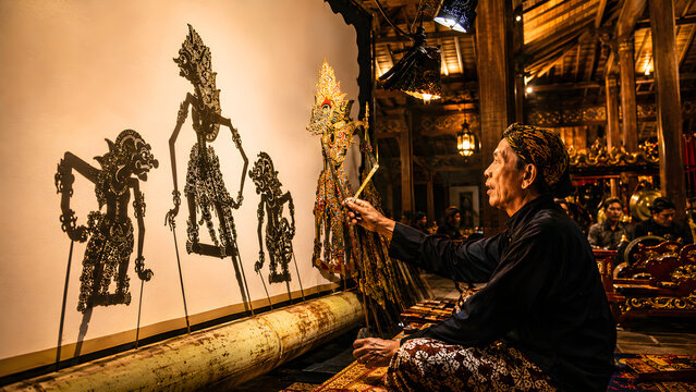 Man preparing traditional balinese wayang kulit shadow puppets for performance in indonesia
