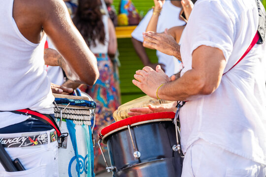 Drummers beating on drums with their hands