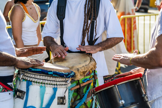 Drummers beating on drums with their hands
