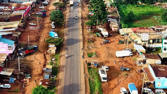 kenya roads, rural roads, poor rural settlement, damaged road with drone tracking vehicles over the road in the air.