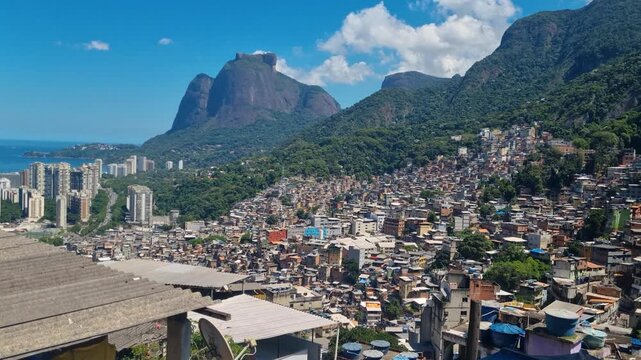 Panoramic view of Rocinha favela in Rio de Janeiro, Brazil, featuring densely packed hillside homes nestled within the city's characteristic tropical mountain landscape