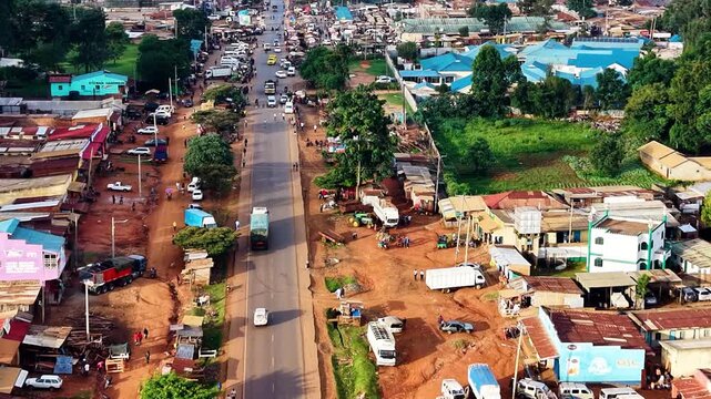 kenya roads, rural roads, poor rural settlement, damaged road with drone tracking vehicles over the road in the air.