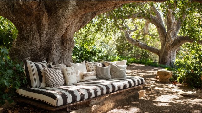 Outdoor daybed beneath large tree branches