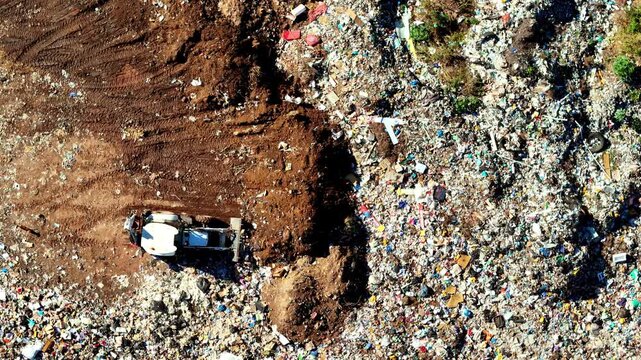 Front end loader moves debris at a large garbage dump, environmental topic