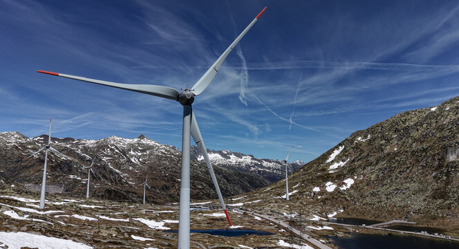 Aerial view of the Gotthard Wind Farm turbines with red-tipped blades on the rocky slopes of the Gotthard Pass with snow-capped peaks and alpine lakes in Airolo, Ticino, Switzerland.