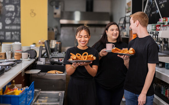 Cafe team serving churros and coffee at the counter