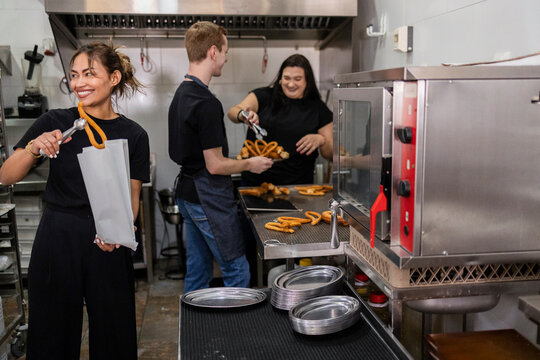 Food service team preparing fresh churros in a busy kitchen