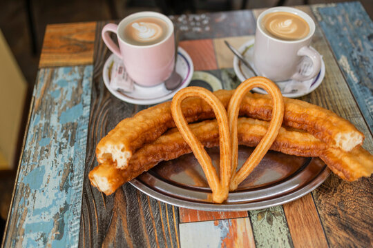 Churros and coffee on rustic table for breakfast moment
